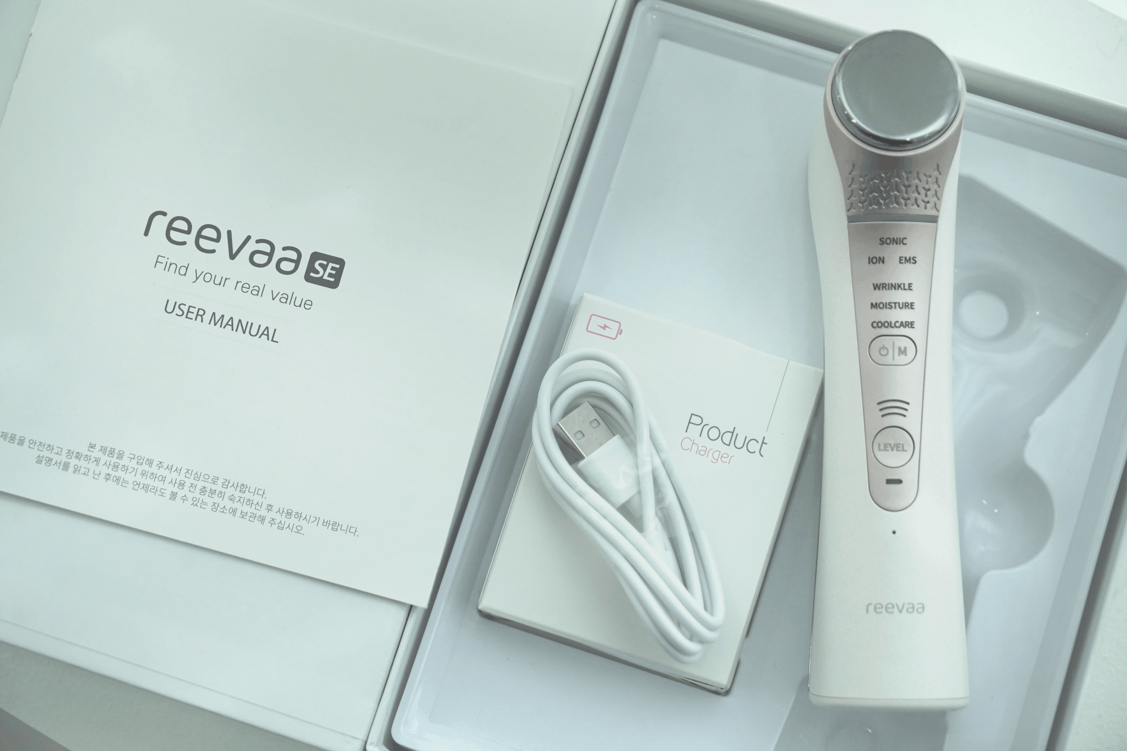 White skincare device with USB cable and user manual